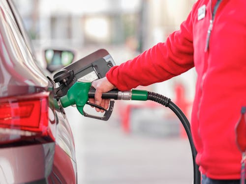 Closeup of man pumping gasoline fuel in car at gas station