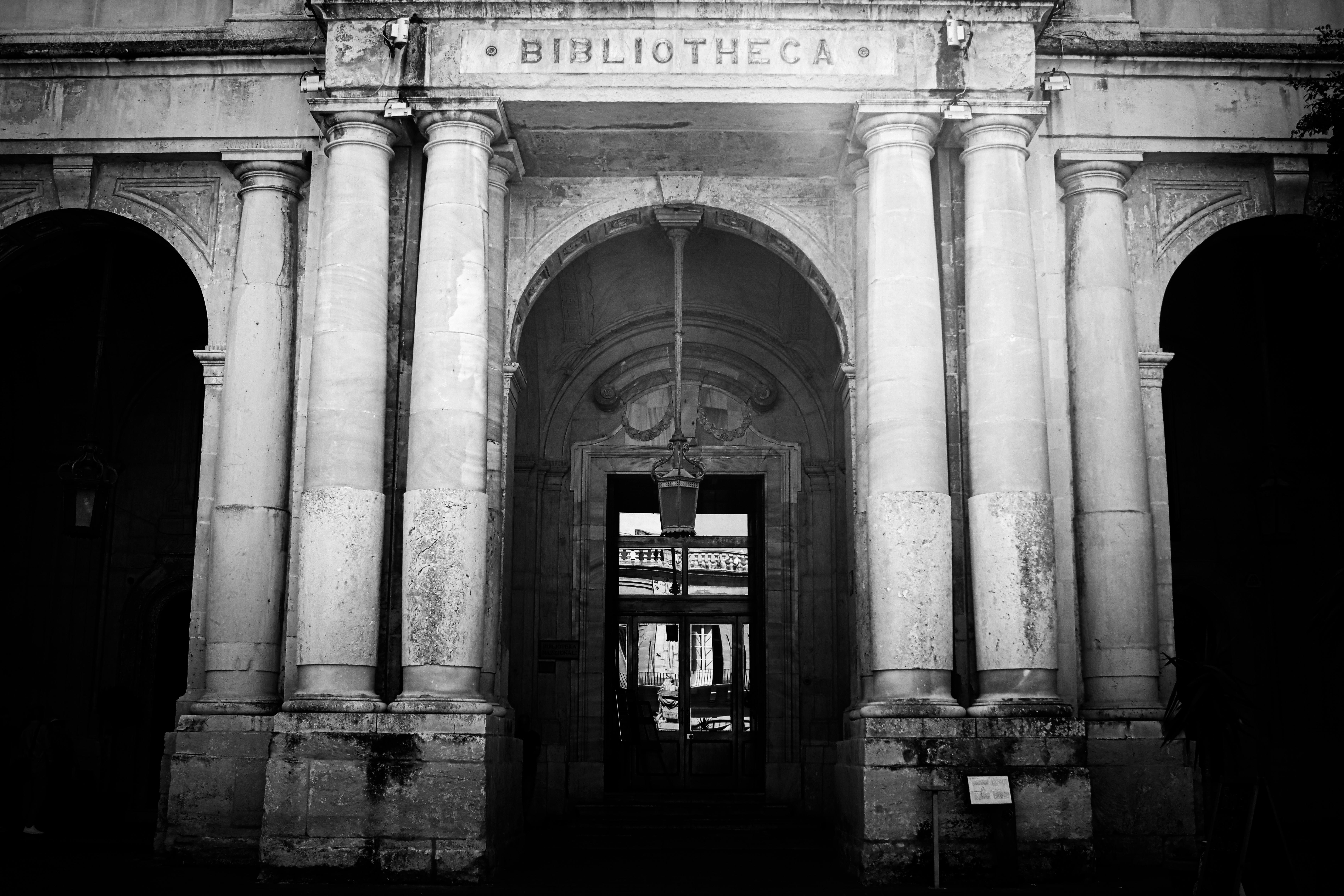 Black and white photo of the historic Bibliotheca entrance in Valletta, Malta, showcasing classic architecture.
