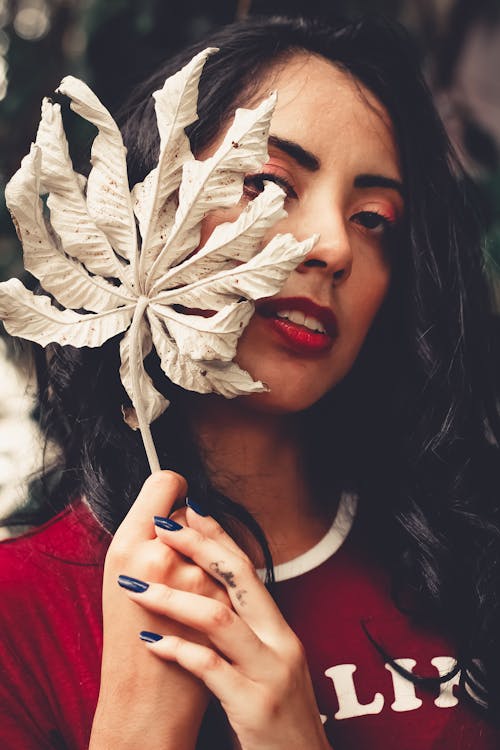 Woman Wearing Red Crew-neck Top Holding Brown Leaf