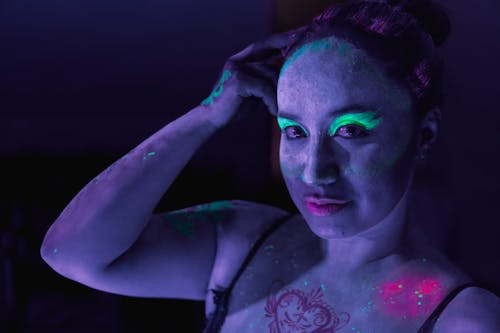 Photo of a Woman Wearing Glowing Makeup under UV Lights