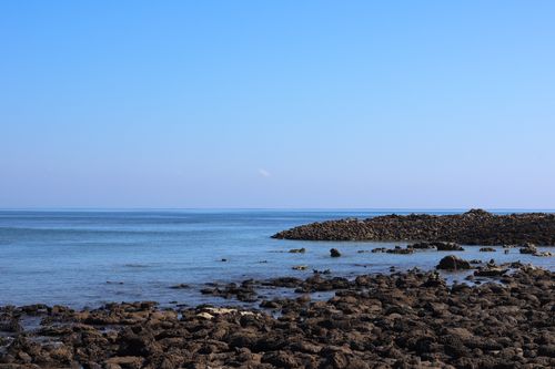 Free A serene view of a rocky seashore under a clear blue sky in Cox's Bazar, Bangladesh. Stock Photo