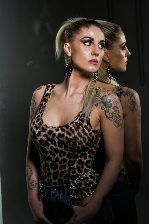 A woman with tattoos and a leopard print top