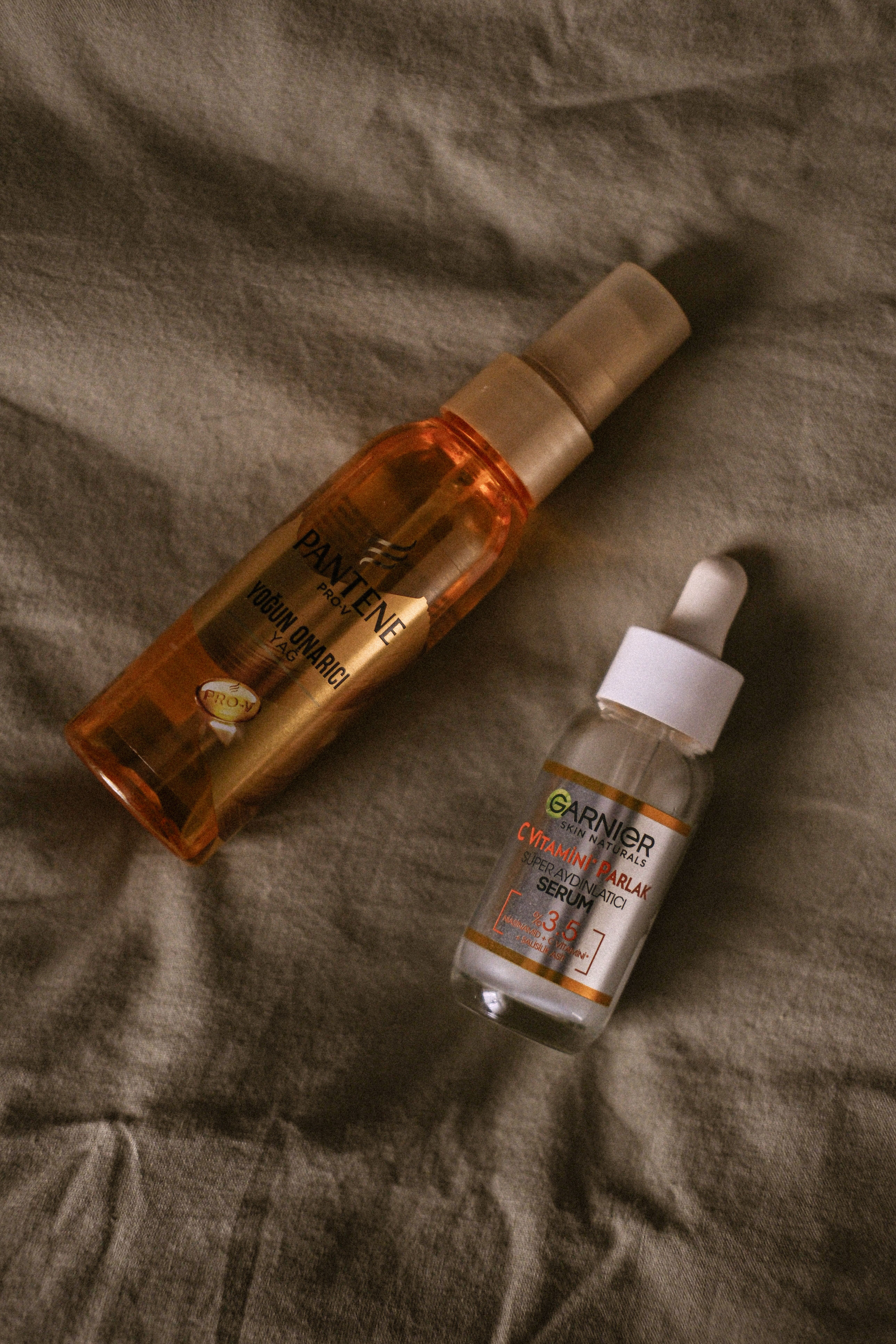 Two bottles of oil on a bed
