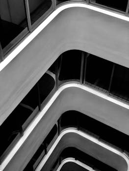 现代建筑的黑白抽象视图，呈现出光滑的曲线与玻璃反射