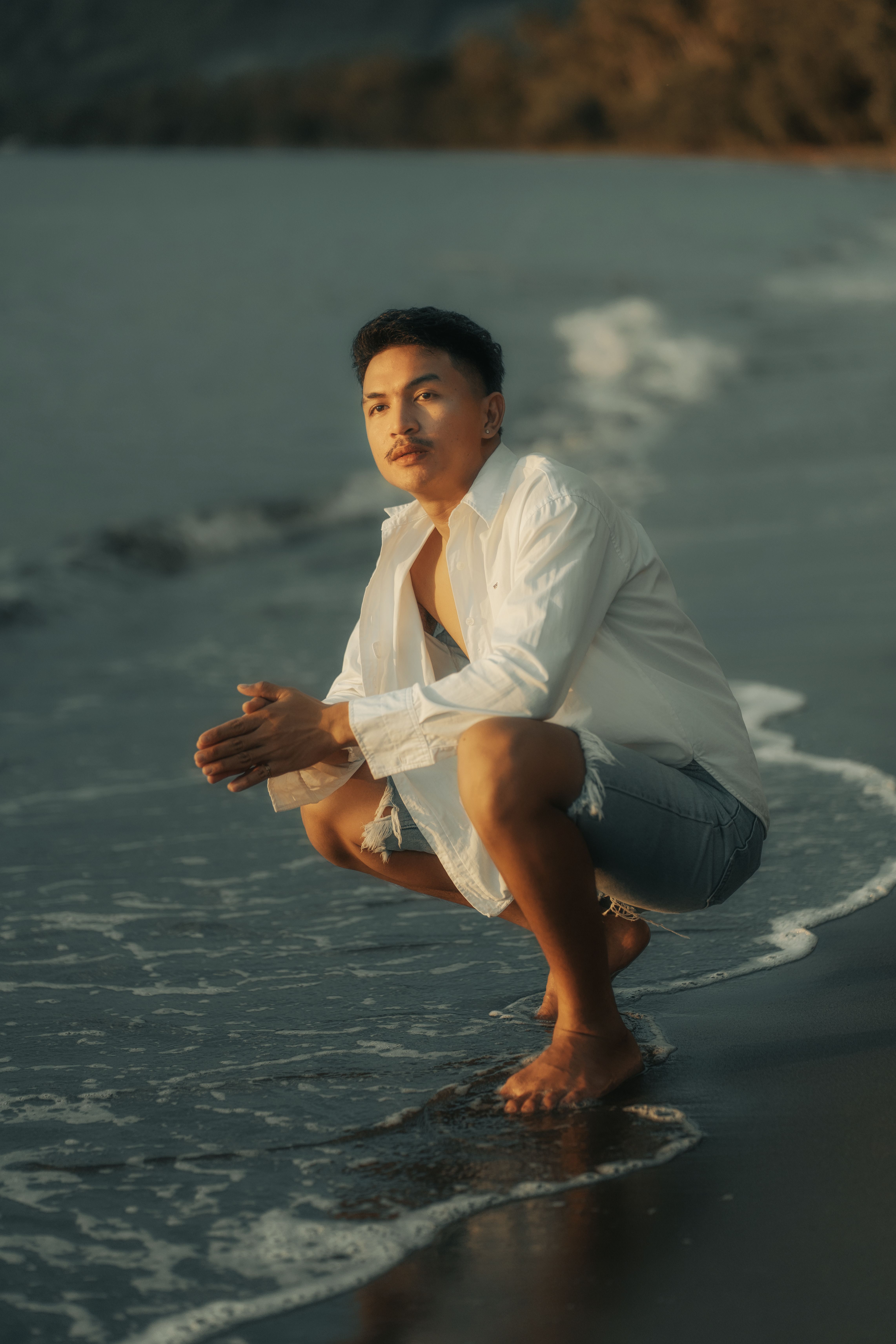 Young Man in a White Shirt and Denim Shorts on the Beach · Free Stock Photo