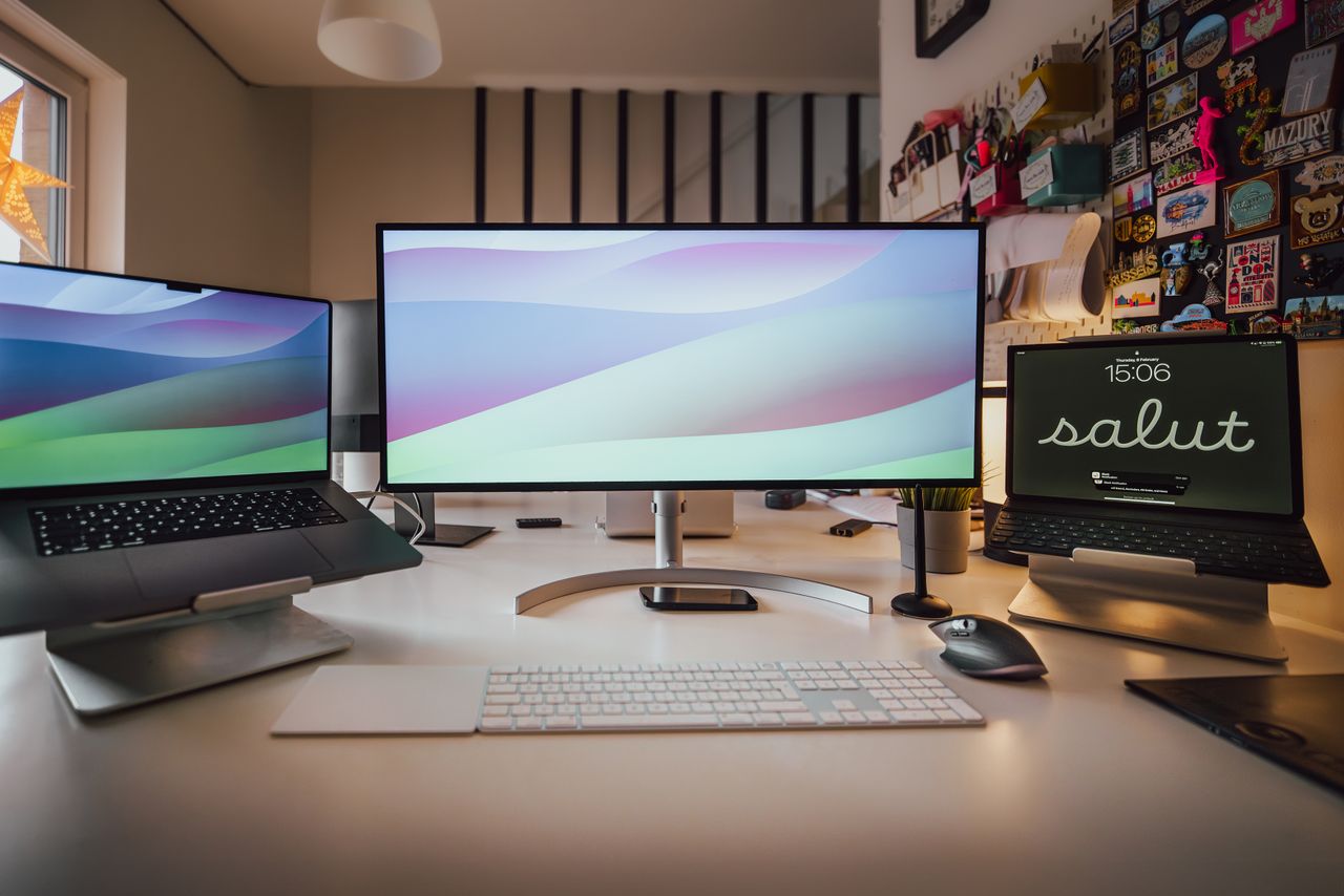a well organized home office setup featuring multiple screens and a ti