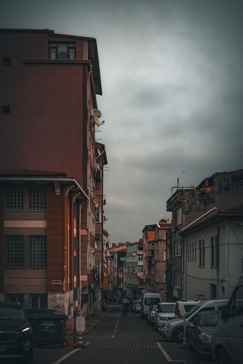 Free Street view in Istanbul with parked cars and historic buildings, captured at dusk, showcasing urban life. Stock Photo