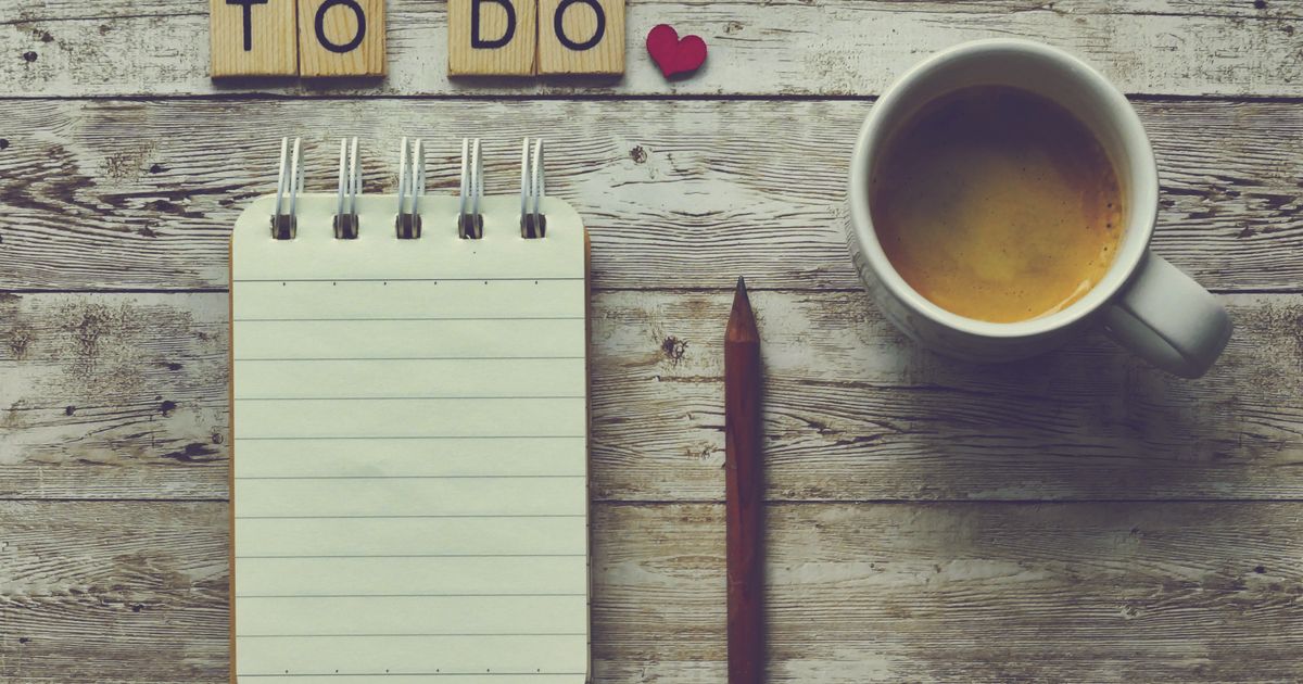 An open notepad with a pen resting beside a morning coffee, ready to hold a single written sentence.