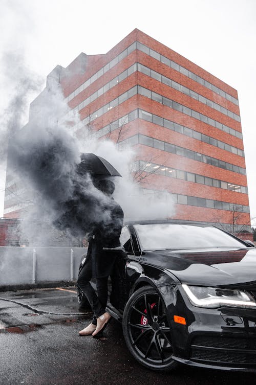 Foto De Um Homem Apoiado Em Um Carro Preto