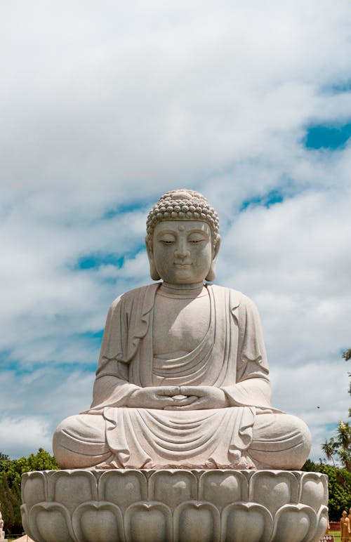 A large buddha statue sitting on a white pedestal