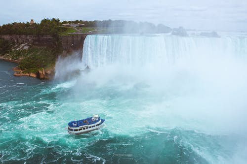 A boat is traveling through the water near niagara falls