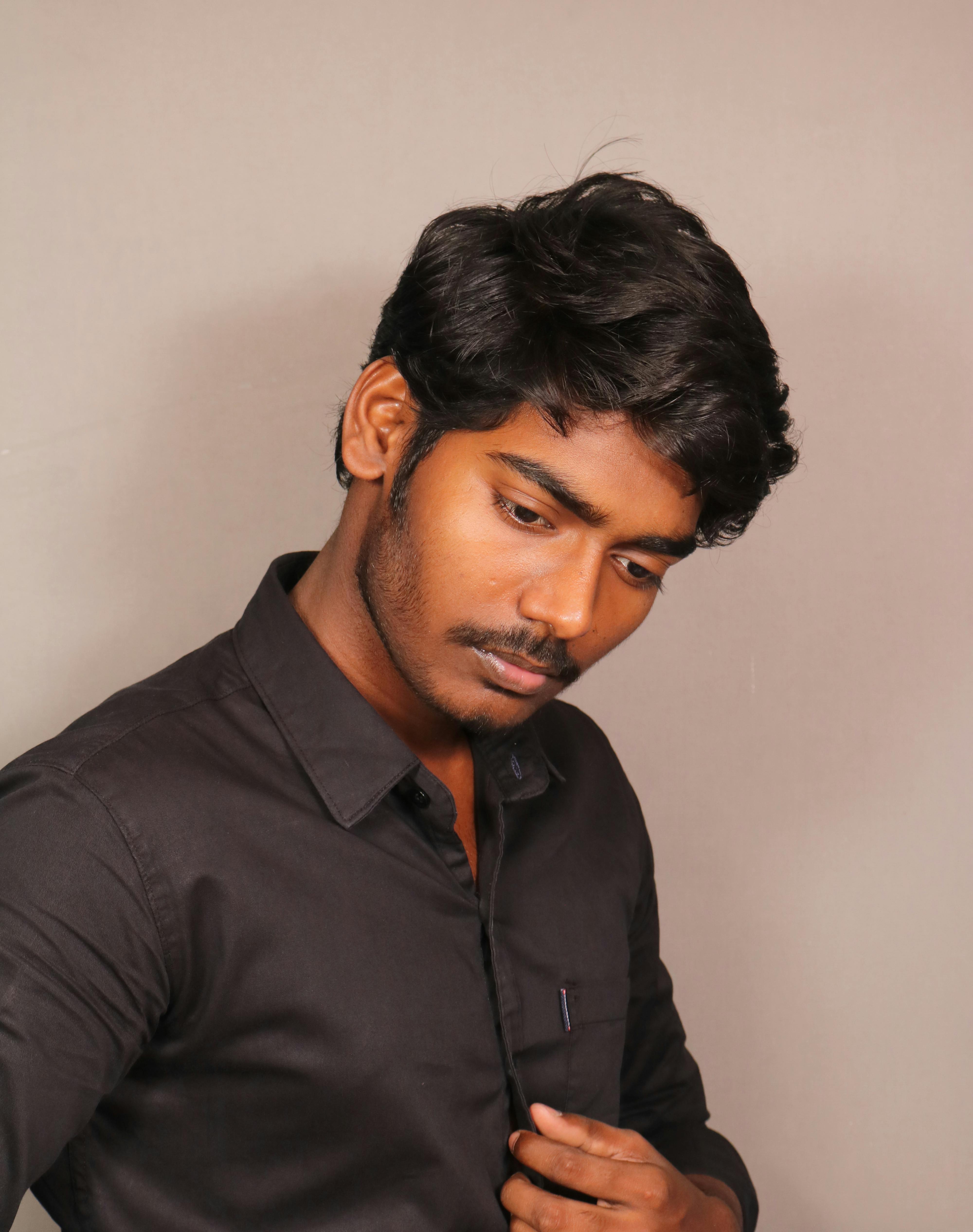 A thoughtful man in a black shirt captured in a classic portrait style.