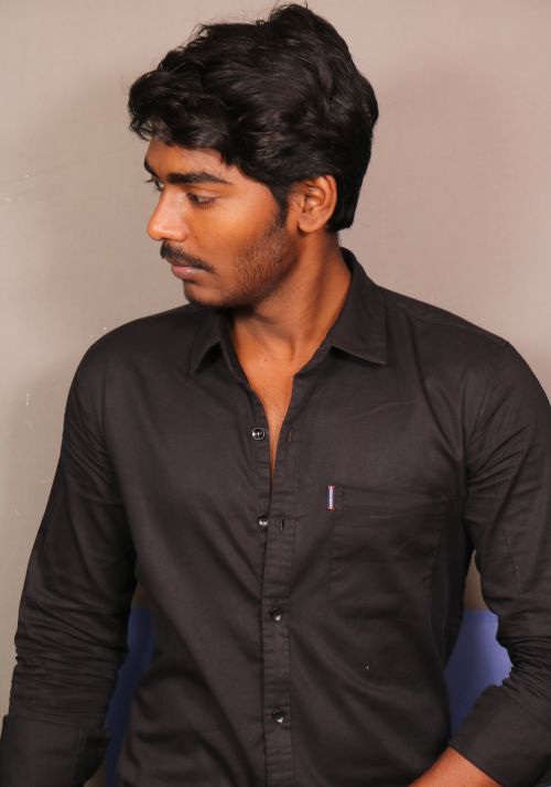 Free Portrait of a man in a black shirt looking away, showing poise and style. Stock Photo
