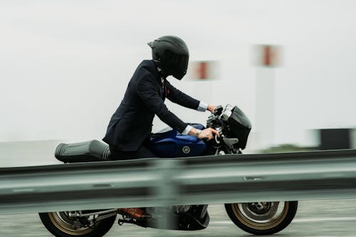 A man in a suit riding a motorcycle