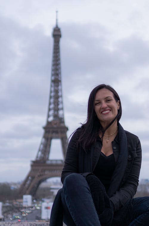 A woman sitting on the ground in front of the eiffel tower