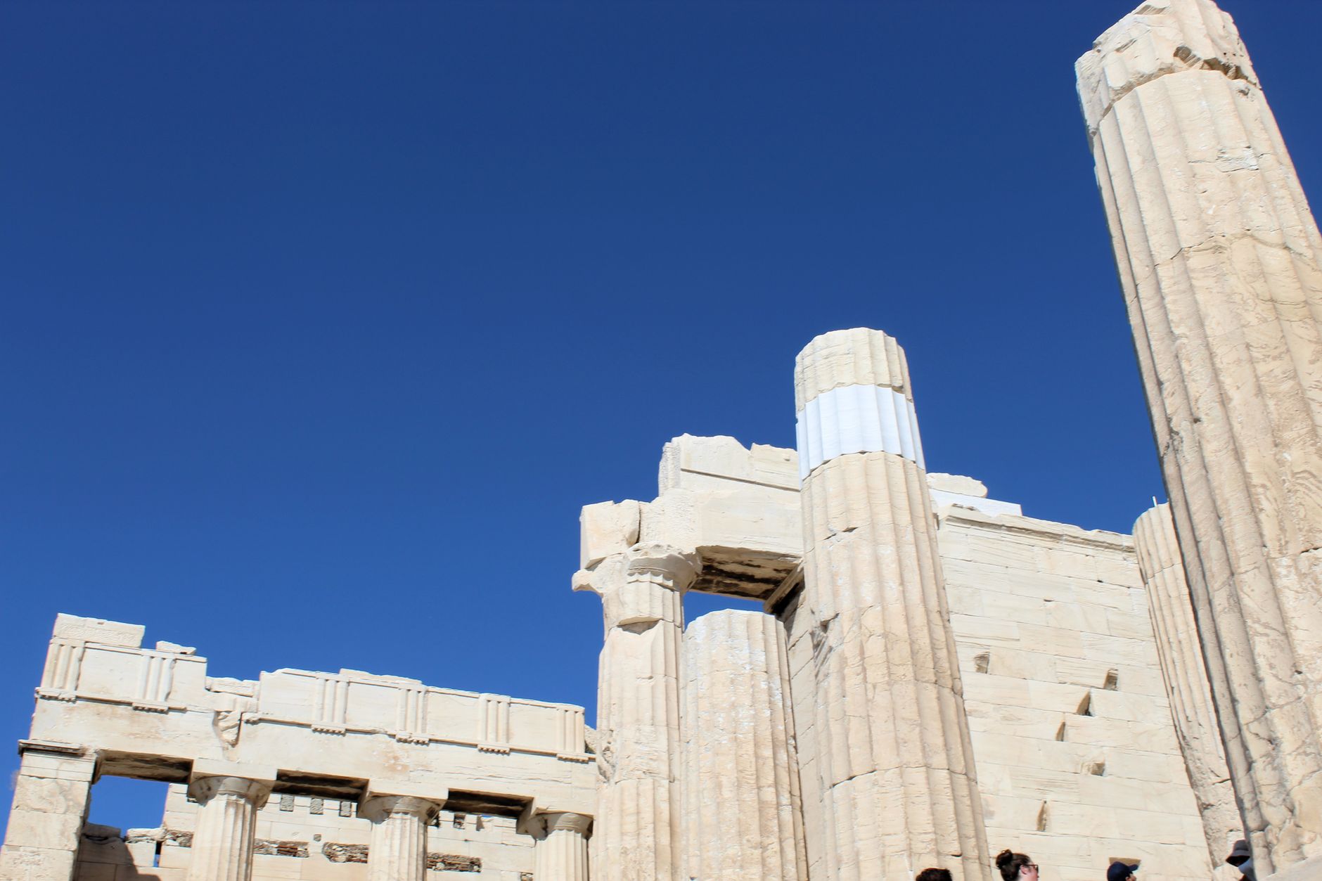 Low-angle view of the Parthenon's ancient columns, Athens, under a clear blue sky.