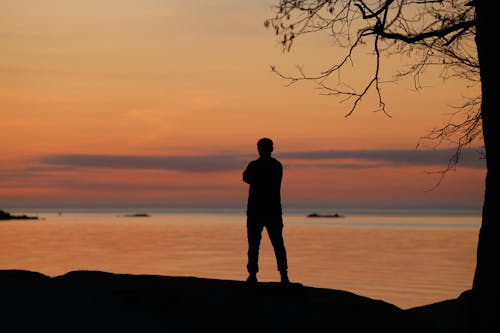 Silhouette of a Person on the Seashore at Dusk