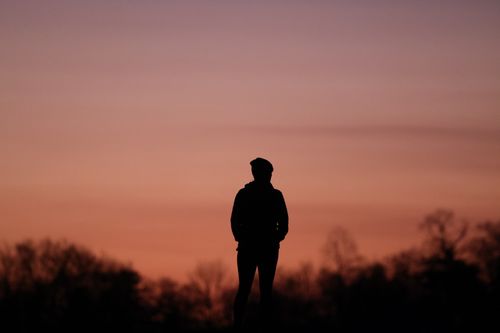 Free Person silhouetted against a vibrant sunset in Stamford, CT, creating a dramatic and serene scene. Stock Photo