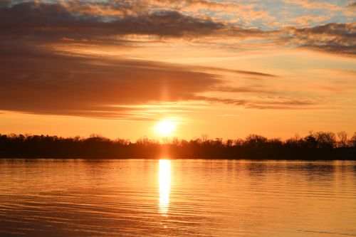 Free A serene sunset casting vibrant colors over a peaceful lake in Stamford, CT. Stock Photo
