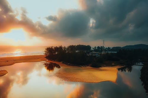 A sunset over a beach with a river and water