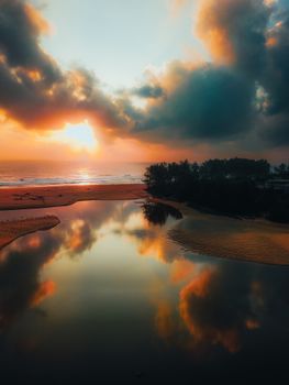 Serene beach sunset captured in Kijal, Malaysia, with reflection of vibrant sky in calm water.