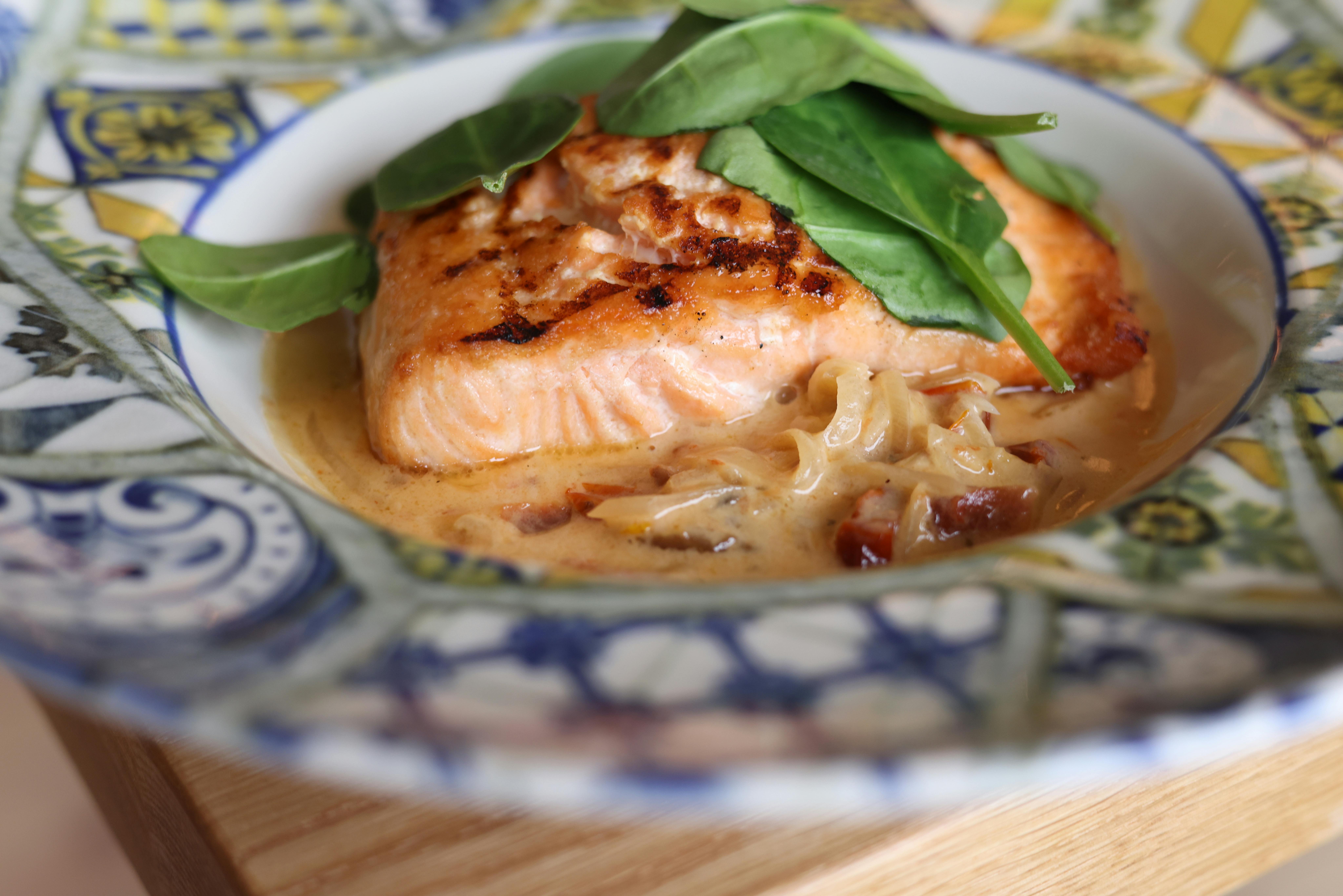 A plate with salmon and spinach on it