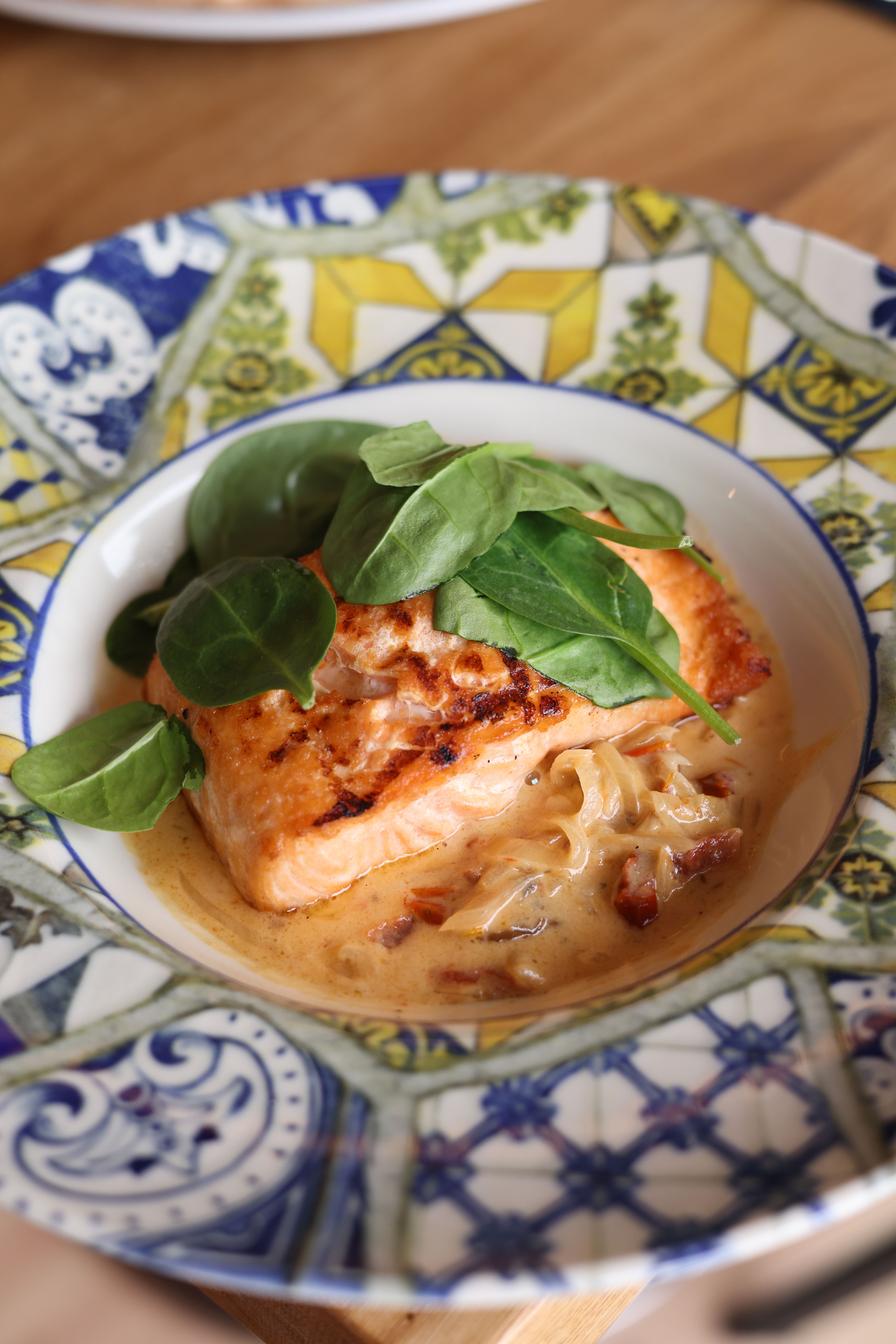 Delicious salmon served with creamy sauce and fresh spinach. Perfect for gourmet meals.