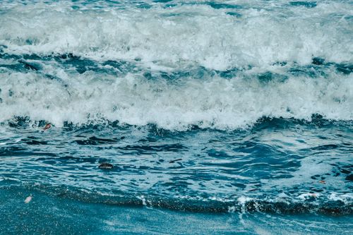 Free Dynamic waves of the ocean creating frothy splashes on the shoreline, showcasing nature's power and beauty. Stock Photo