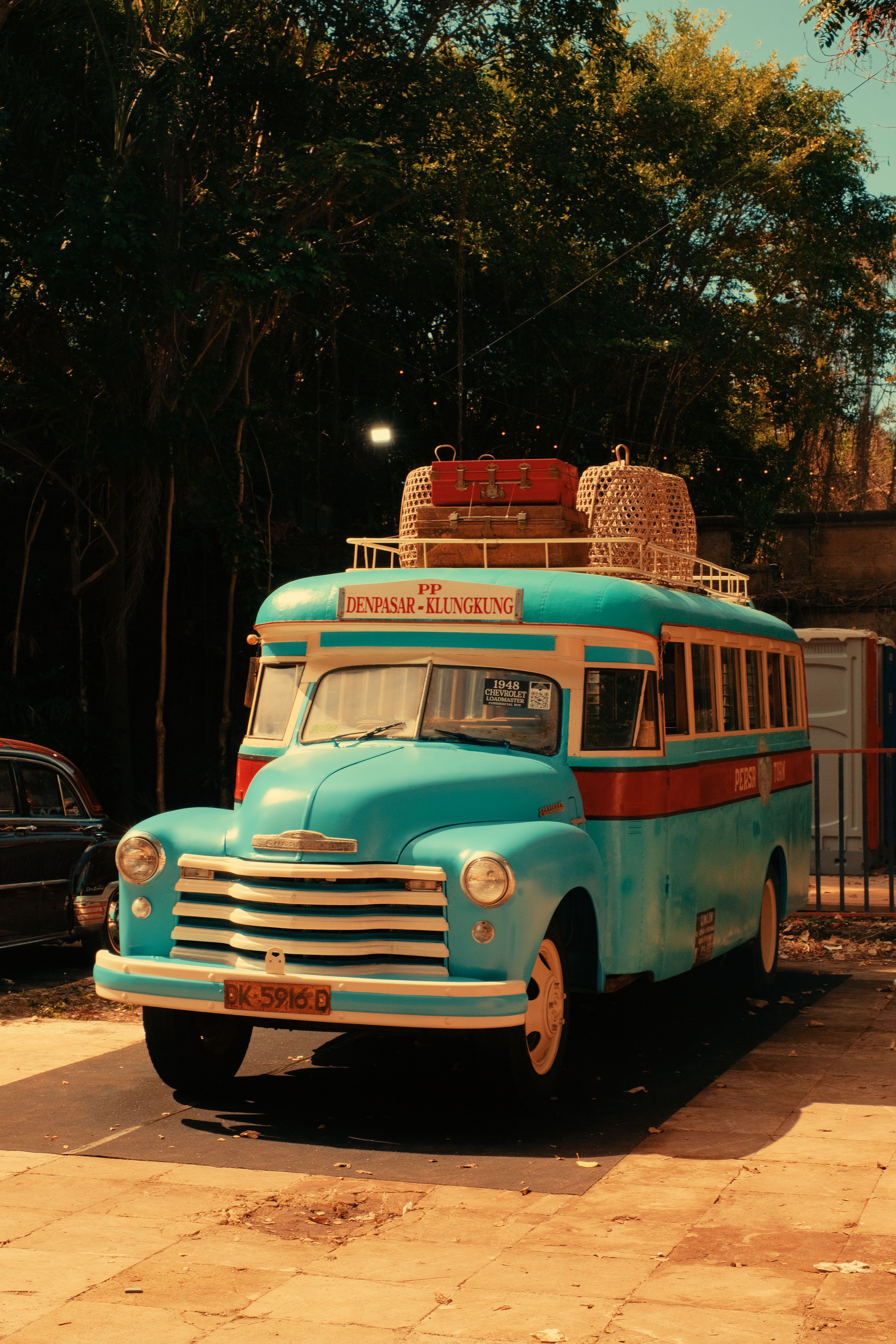 Turquoise vintage bus parked outdoors with retro decor, capturing a classic travel vibe.