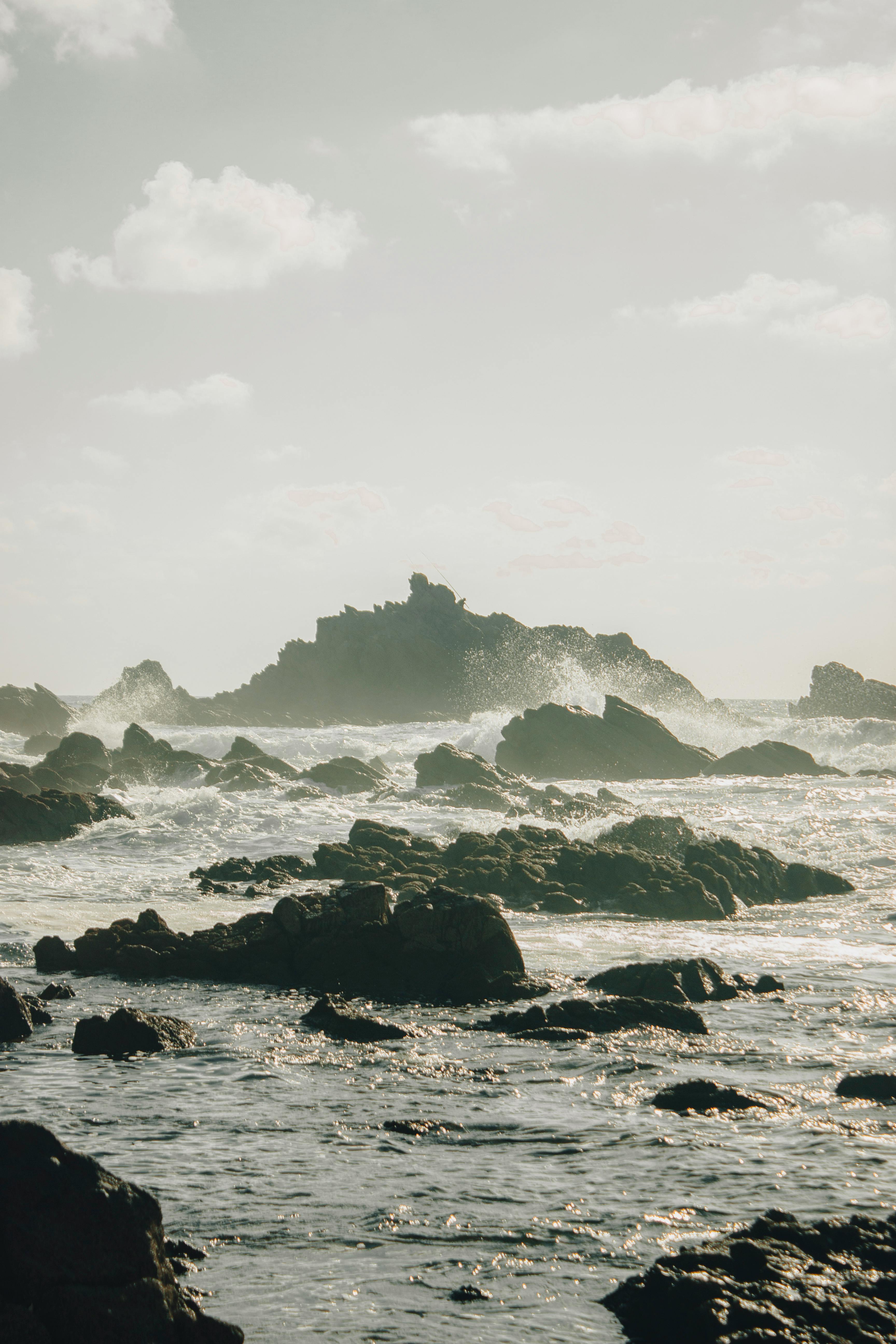 Stunning view of rocky shoreline with ocean waves during dawn in Mirleft, Morocco.