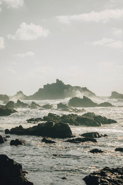 Stunning view of rocky shoreline with ocean waves during dawn in Mirleft, Morocco.