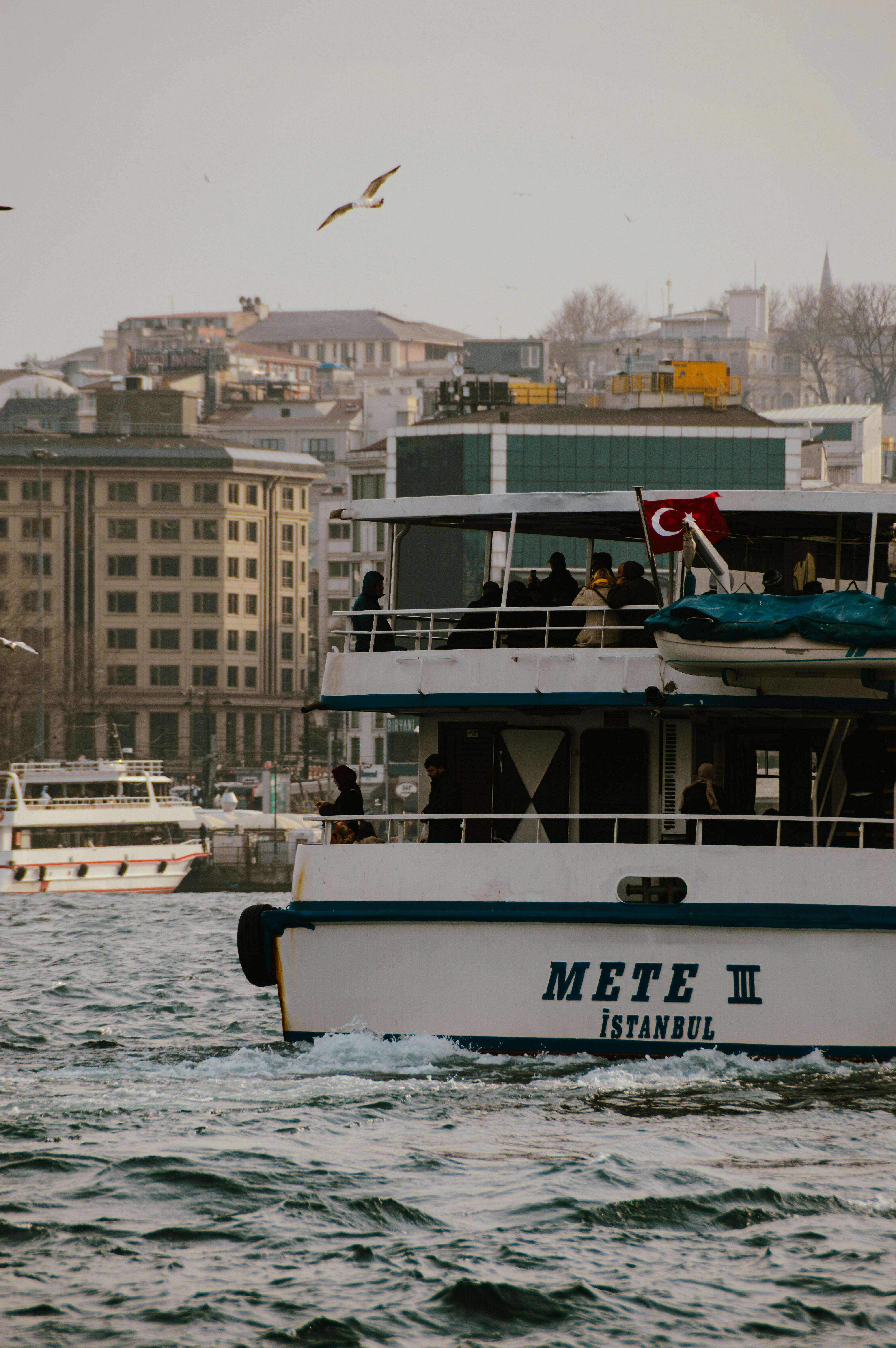 Ferry navigating through Istanbul with views of the city's historic skyline and Turkish flag.