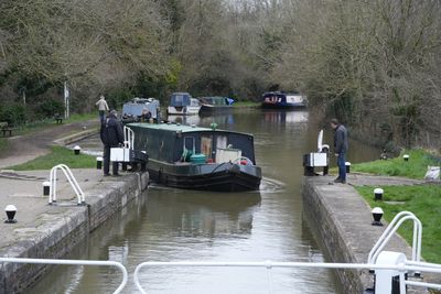 Narrowboat entering a lock beside a towpath, photo by Malcolm Stirling on Pexels