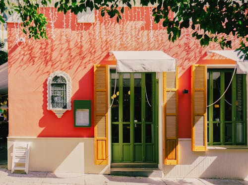 A colorful building with a green door and yellow shutters