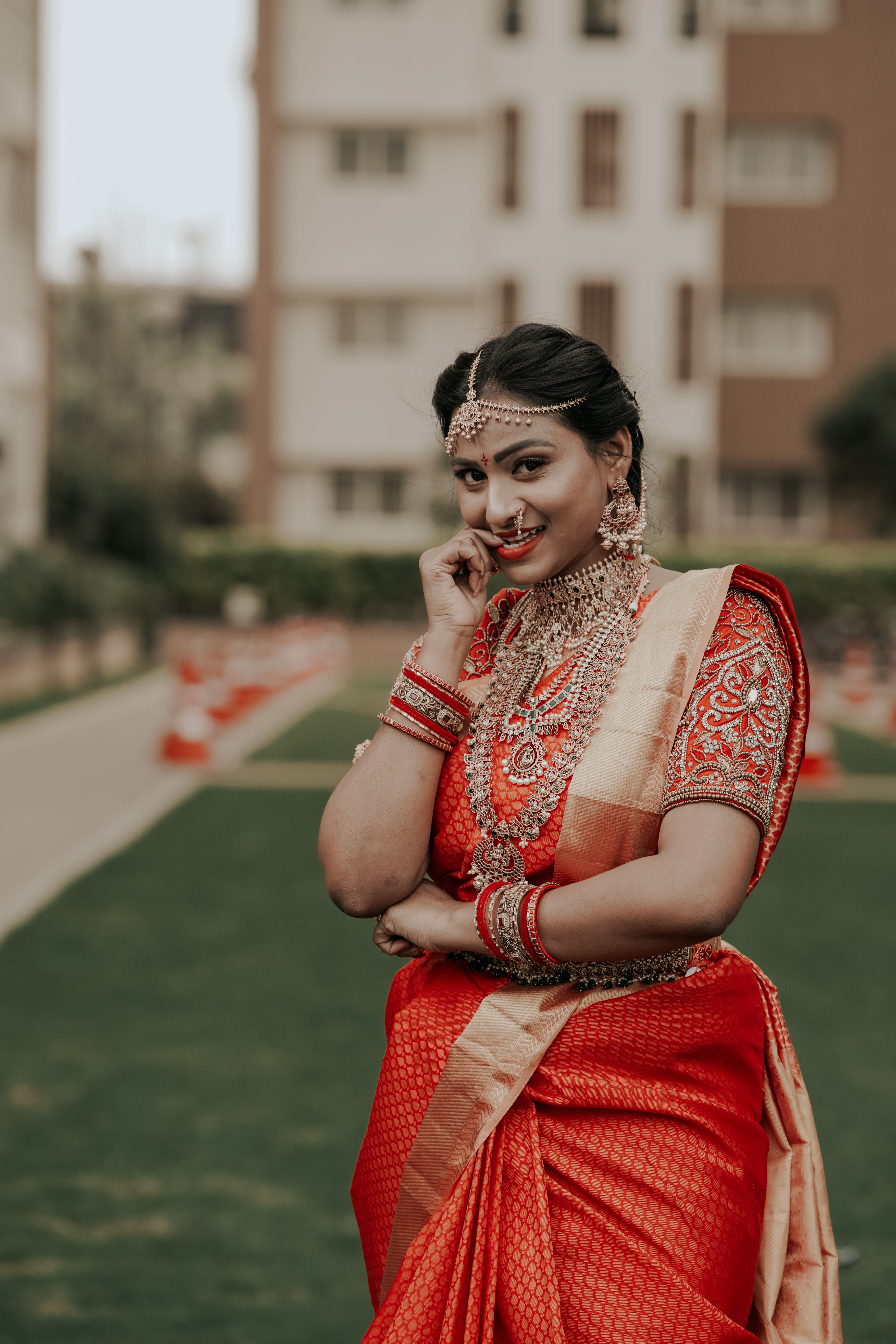 Smiling woman in a traditional red saree and jewellery (House Party Catering in Vellore)