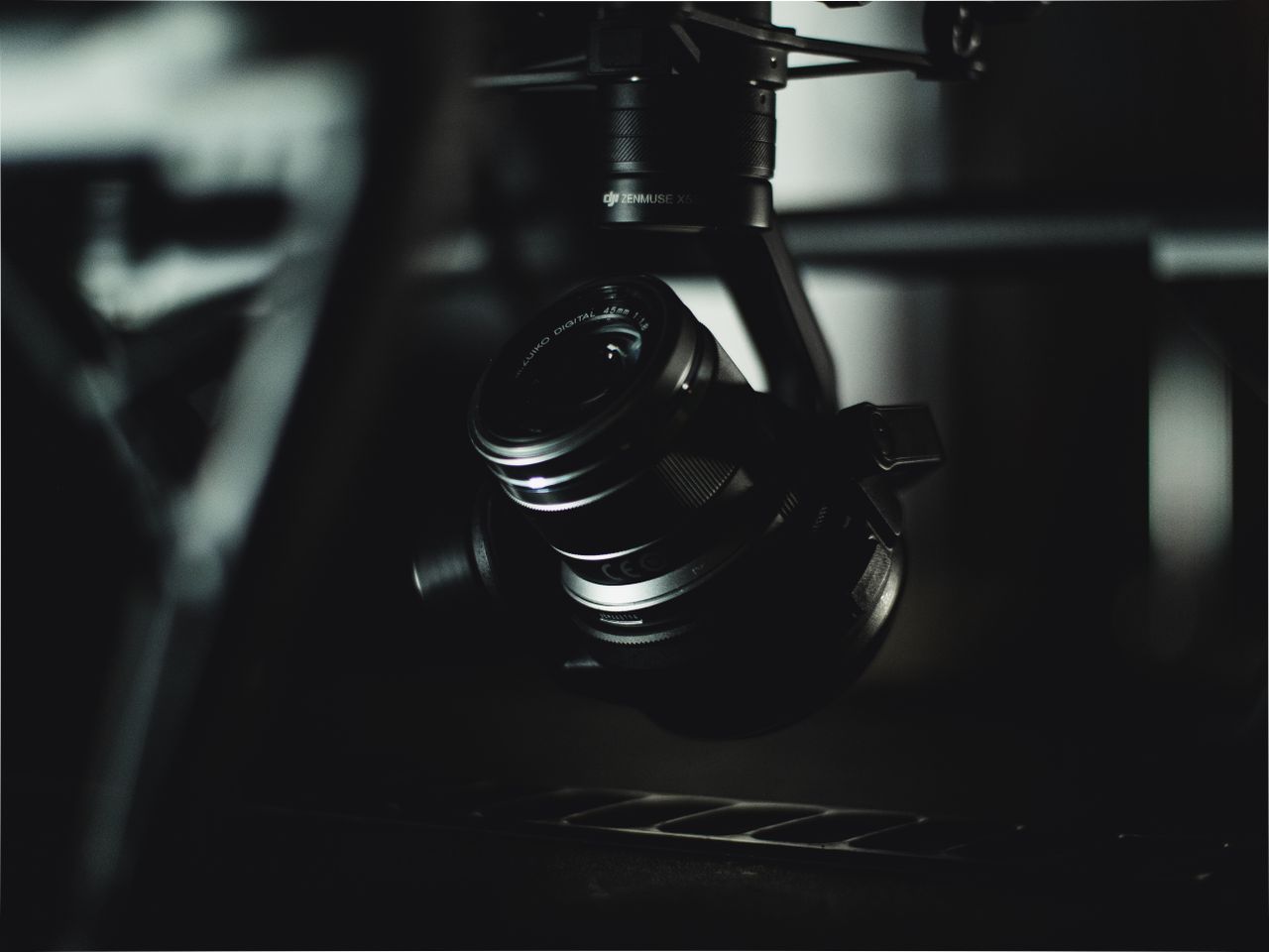 detailed close up of a camera lens mounted on a gimbal in low light