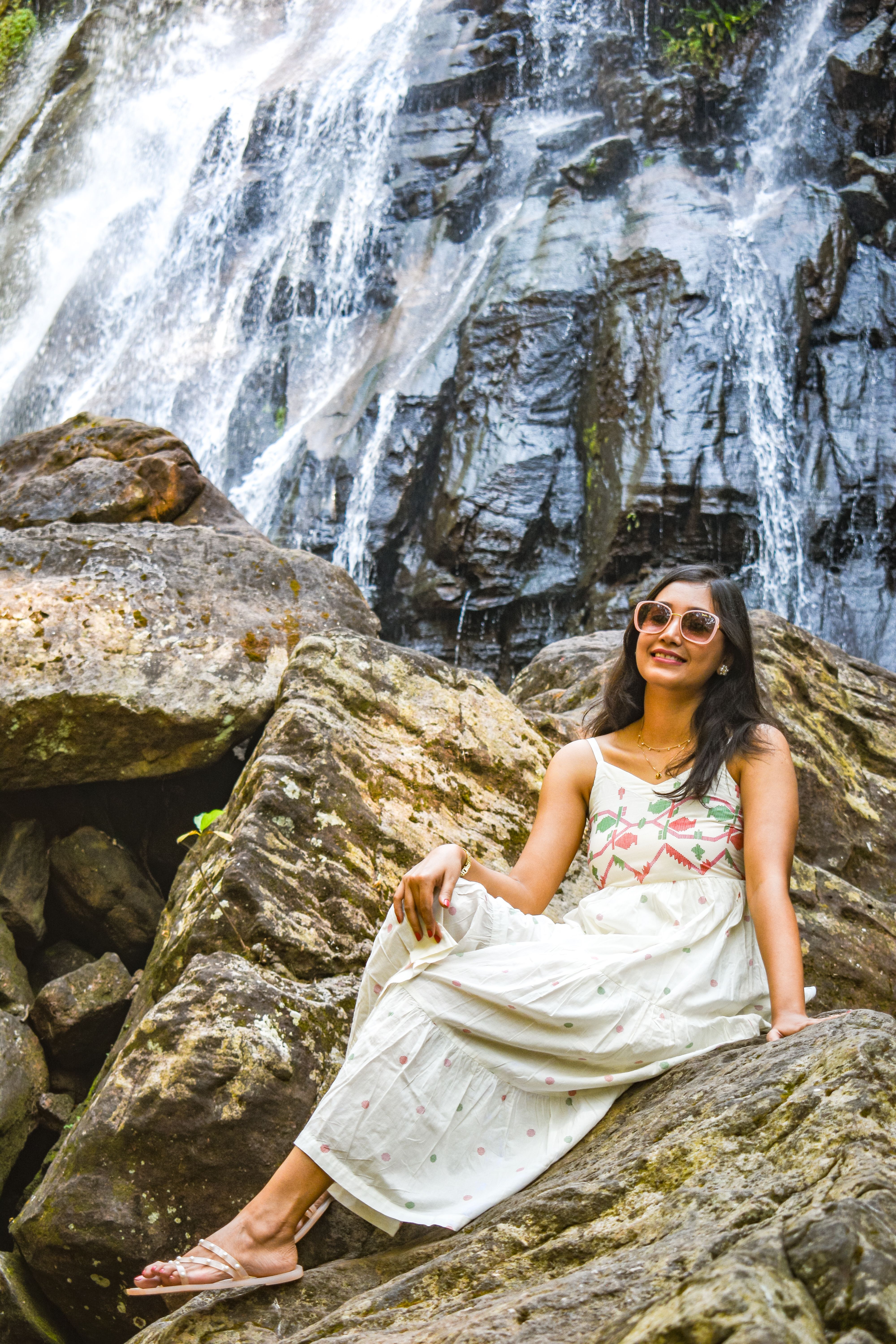 Woman in Dress Sitting on Rock Formation by Waterfall · Free Stock Photo
