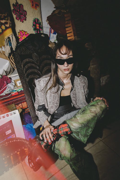 A woman in sunglasses sitting on a chair