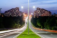 这张长时间曝光的基什林图高速公路照片，展现了夜间灯光小径和城市天际线