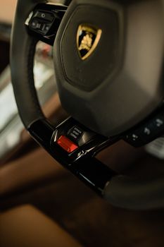 Close-up of a Lamborghini steering wheel showcasing luxury design and detail.