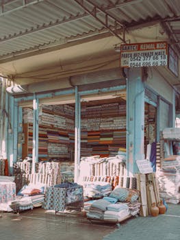Vibrant display of textiles and fabrics at an outdoor Turkish bazaar during the day.