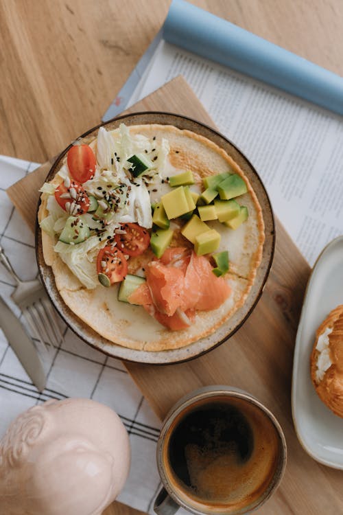 Cup of Coffee and a Wrap with Avocado Tomatoes and Smoked Salmon