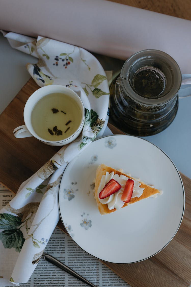 Green Tea And Cheesecake With Whipped Cream And Strawberry