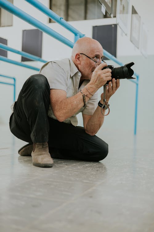 A man crouching down with a camera in his hand