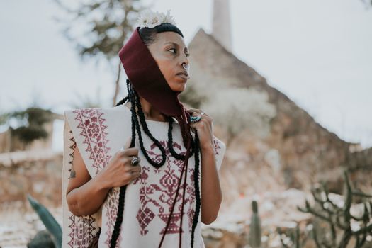 A woman in a maroon and white dress with a head wrap