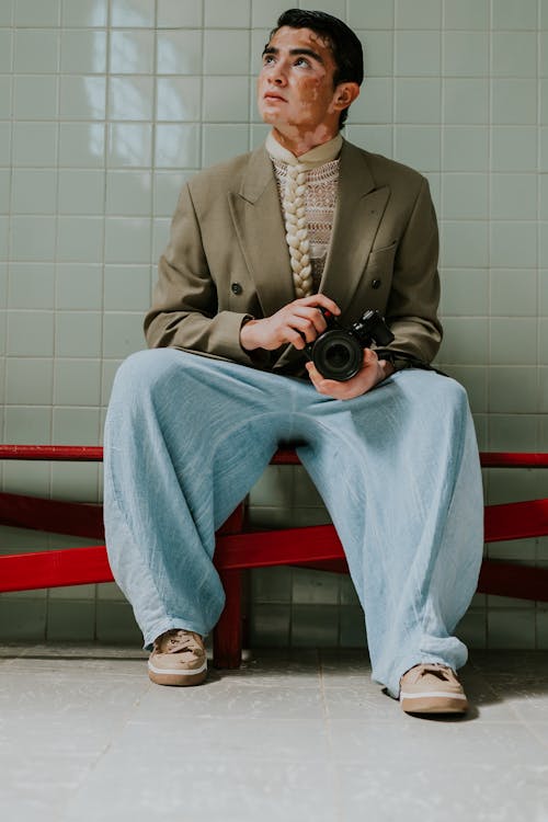 Man in Suit Jacket Sitting with Camera