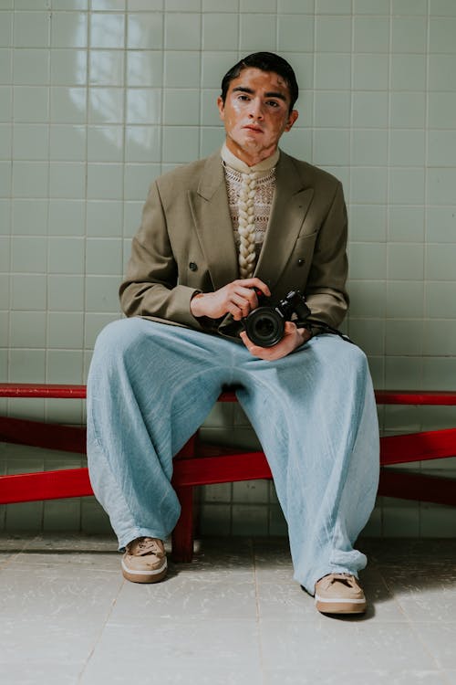 A man sitting on a bench with a camera