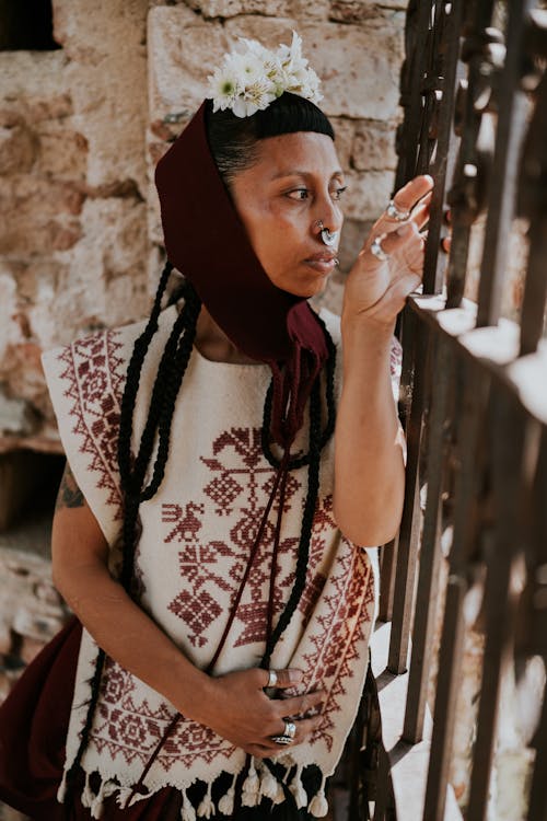 A woman in a traditional mexican dress smoking a cigarette