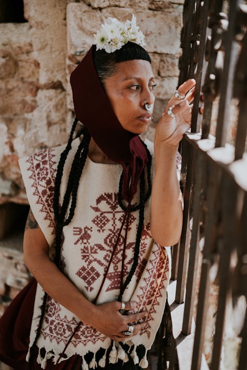 Woman in Shawl and Traditional Clothing Standing by Fence