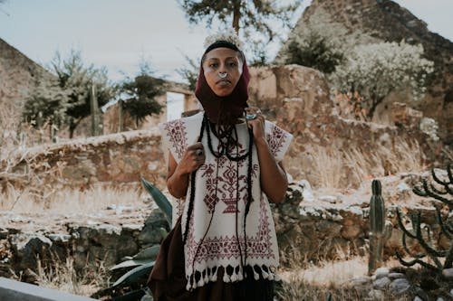 A woman in a traditional mexican dress standing in front of cactus